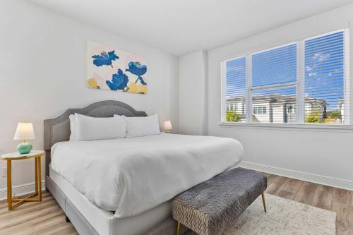 a white bedroom with a large bed and a window at LC517T The Chic Abode at Liberty Bluff in Kissimmee