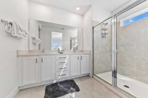 a white bathroom with a shower and a sink at LC517T The Chic Abode at Liberty Bluff in Kissimmee