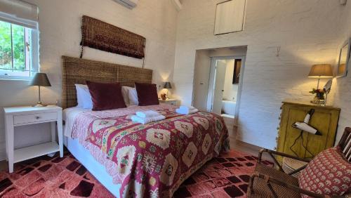 a bedroom with a large bed with a red blanket at Bramber cottage Stay a while in Stanford
