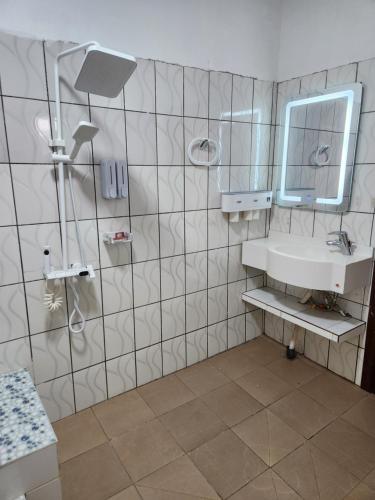 un baño con lavabo y espejo en Ndouha House, en Bafoussam