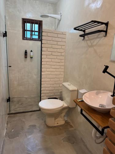 a bathroom with a toilet and a sink at Lua Chalés 14 chalés equipados com churrasqueira, piscina e hidro incluindo café da manhã , roupa de cama, toalhas de banho e de praia a apenas 600 metros da praia de Maresias in Maresias