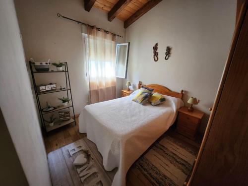 una camera da letto con un letto bianco e un pavimento in legno di Encanto Rural ad Arnedillo