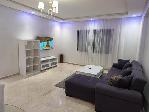 a living room with a couch and a table at Apartment kamal park in Mohammedia