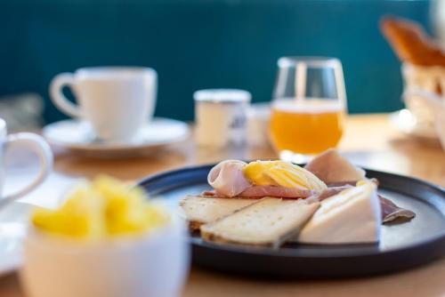 Un plato de comida en una mesa con un vaso de jugo de naranja. en Le Bel Abri, en Annecy