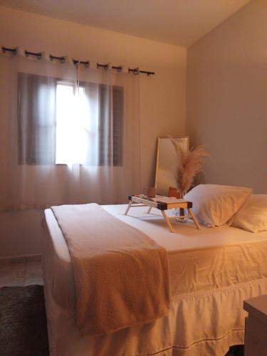 a bedroom with a white bed with a window at Pousada São Jorge in Araxá