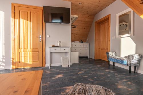 een keuken met houten plafonds en een houten deur bij Osada Witów - apartament „Niebieska Turnia” in Witów