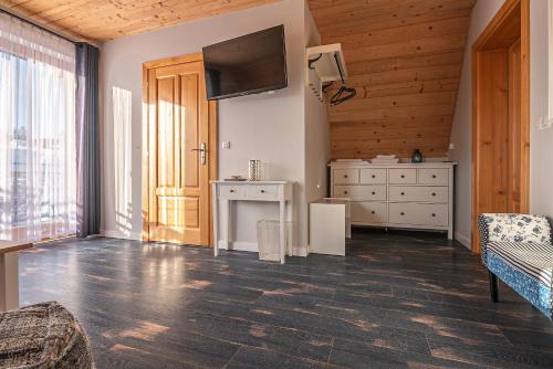 een woonkamer met een televisie en een dressoir bij Osada Witów - apartament „Niebieska Turnia” in Witów