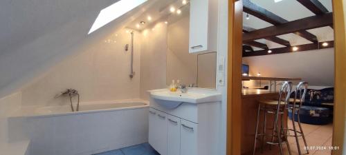 un bagno con un lavandino e una vasca da bagno accanto a un bancone di DIE HOTELALTERNATIVE DELUXE APP erste Etage mit 2 Schlafzimmer Haus 63 a Solingen