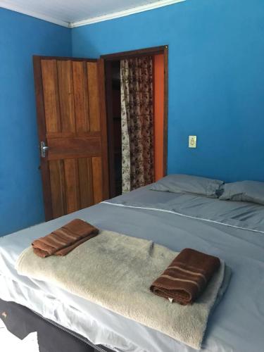 two towels on a bed in a room with a door at Camping-Casa Saco do Ceu in Saco do Ceu