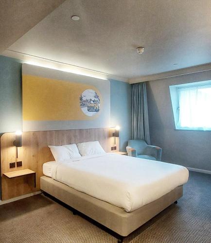 a bedroom with a large bed and a window at B&B HOTEL London Heathrow in Slough