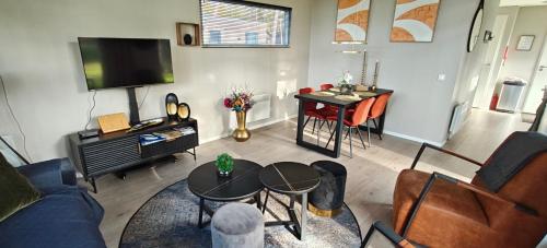 a living room with a couch and a table at Casa Kwispel - Hondvriendelijk, luxe, natuur, omheinde tuin in Haarle