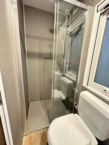 勒波泰勒Blueportel Mobil-home Prestige face à la mer的浴室配有马桶和玻璃淋浴房