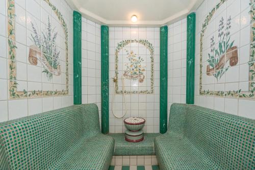 een badkamer met twee groene banken en een toilet bij Kampen Royal in Kampen