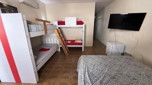 a bedroom with two bunk beds and a television at Casa do Uai in João Pessoa
