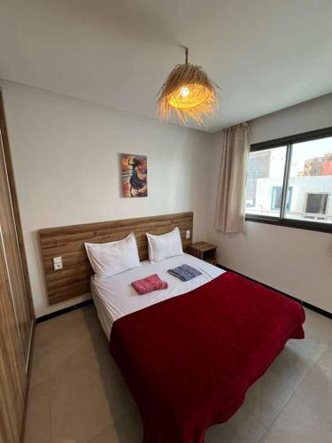 Un dormitorio con una cama grande con una manta roja. en Atlantic view Tamraght, en Tamraght Ou Fella