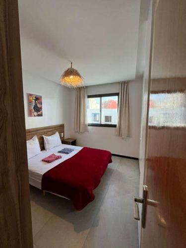 Un dormitorio con una cama grande con una manta roja. en Atlantic view Tamraght, en Tamraght Ou Fella