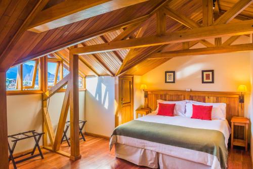 a bedroom with a large bed in a room with wooden ceilings at Hosteria Senderos in El Chalten