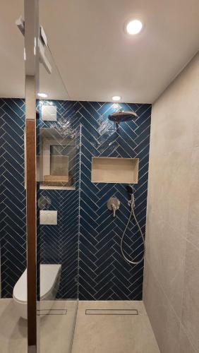 a bathroom with a shower with blue tiled walls at Ferienwohnung Schloßberg 1 in Peiting