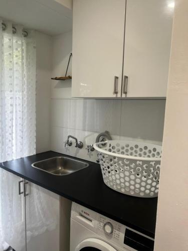 a kitchen with a sink and a washing machine at 3 bedroom Kids friendly home in Perth