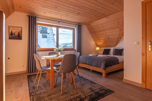 een slaapkamer met een bed, een tafel en stoelen bij Osada Witów - apartament „Siwa Kopa” in Witów