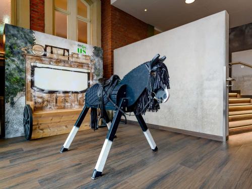 a black horse on a tripod in a room at ibis Styles Coburg in Coburg
