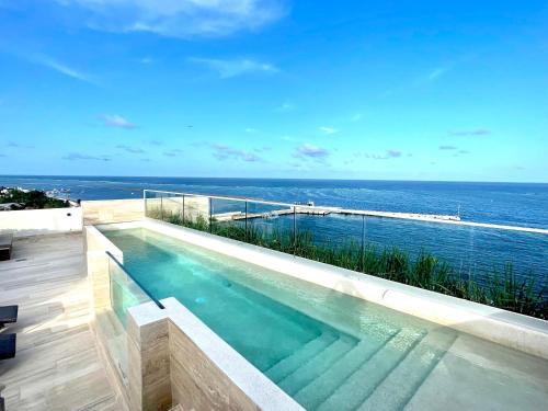 a swimming pool with a view of the ocean at Estudio 104 en Distrito Puerto in Puerto Morelos