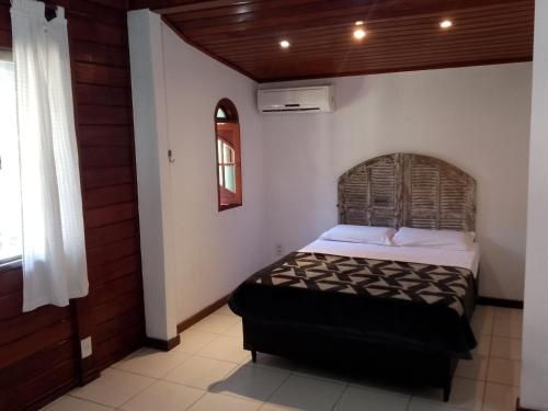 a bedroom with a bed in a room at Alfa Serra lago e montanha in Guapimirim