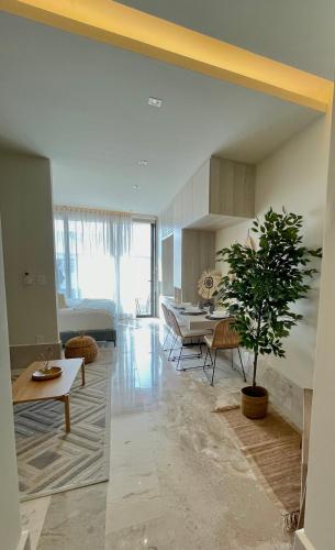 a living room with a table and a plant in it at Estudio 104 en Distrito Puerto in Puerto Morelos