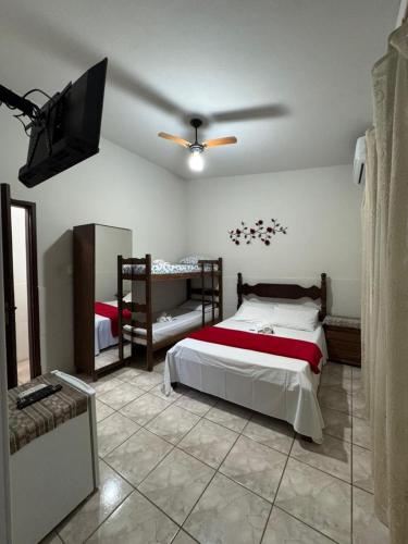 Un dormitorio con dos camas y un ventilador de techo. en Pousada Serra da Canastra 3, en Vargem Bonita