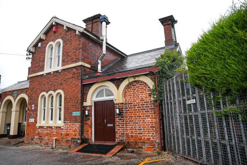 un viejo edificio de ladrillo con una puerta delante de él en The Luma Suite, en Albrighton