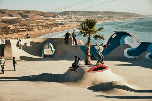 a group of people riding skateboards on a ramp near the beach at L'élégance Taghazout in Taghazout