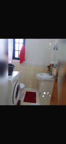 a bathroom with a white toilet and a sink at House Silvia & Nuno´s in Machico