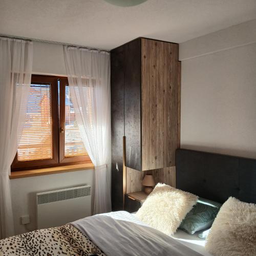 a bedroom with a bed and a window at Apartman Montis in Kupres