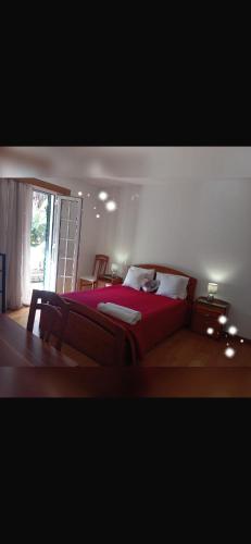 a bedroom with a red bed and a window at House Silvia & Nuno´s in Machico