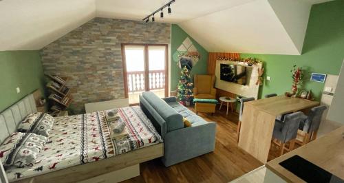 a living room with a bed and a dining room at Zlatarska Studenica in Brdo