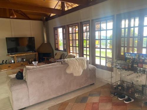 Una sala de estar con un sofá y un televisor. en Refúgios SUNSET Serra Fluminense, en Areal