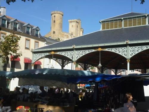 Foix centre - T2 vue sur le Château في فوا: سوق بمظلة زرقاء أمام مبنى