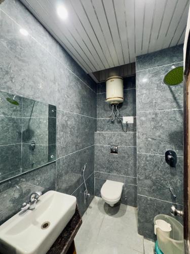 a bathroom with a toilet and a sink at HOTEL Grand JAGDISH RESIDENCY in Katra
