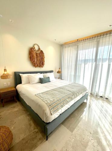 a bedroom with a large bed and a large window at Estudio 104 en Distrito Puerto in Puerto Morelos