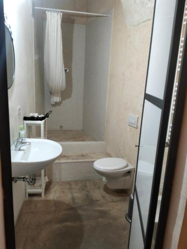 a bathroom with a toilet and a sink at Stone Rooms in Matera