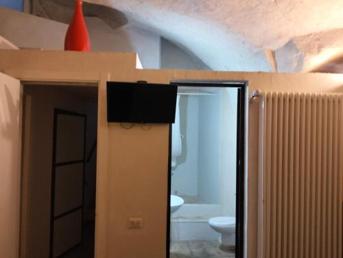 a room with a bathroom with a toilet and an open door at Stone Rooms in Matera
