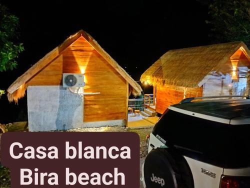 a log cabin with a car parked in front of it at Casablanca Bira Resort in Tabutule