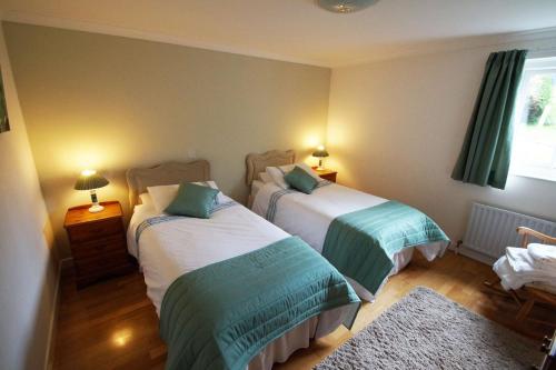ニューポートにあるBwthyn Trefdraethのベッドルーム(緑と白のベッド2台付)
