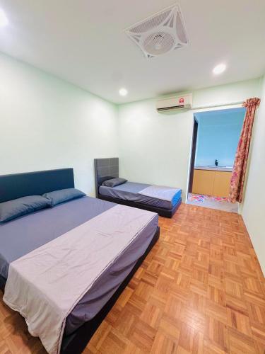 a bedroom with two twin beds and a window at HMHome-Seven in Sibu
