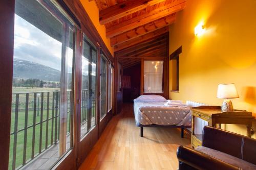 a bedroom with a bed and a large window at Complejo Rural La Venta Vieja by CABANA Rentals in Ortigosa del Monte