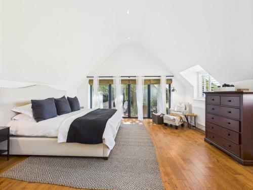 Luxurious 4 Bed Property: Chiltern Hills - Pass the Keys في Ibstone: غرفة نوم بسرير كبير وخزانة