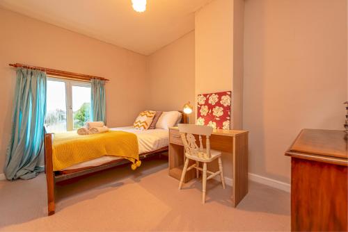 a bedroom with a bed and a desk and a window at Charming Cottage in the Heart of Newport - Pass the Keys in Newport