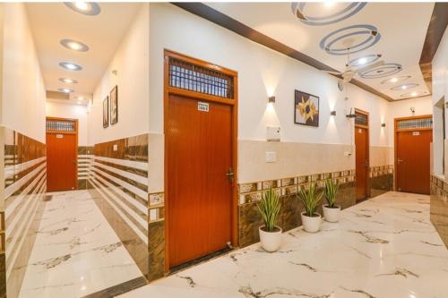 Un vestíbulo con puertas naranjas y plantas en macetas. en Via Shree Siya Raman - 500m from Shri Ram Janam Bhumi, en Ayodhya