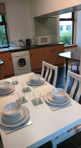 a kitchen with a table with plates and dishes on it at The Haven Cottage in Slamannan