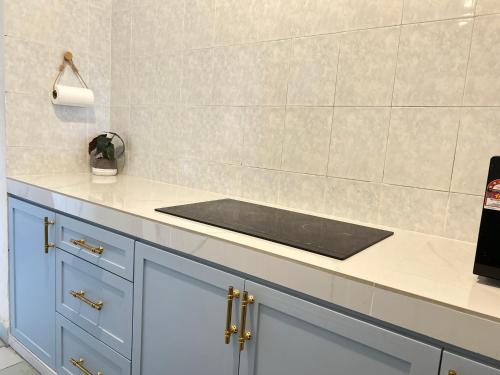 Condo D'Savoy @ Famosa, Malacca في ميلاكا: مطبخ مع دواليب زرقاء وقمة كونتر